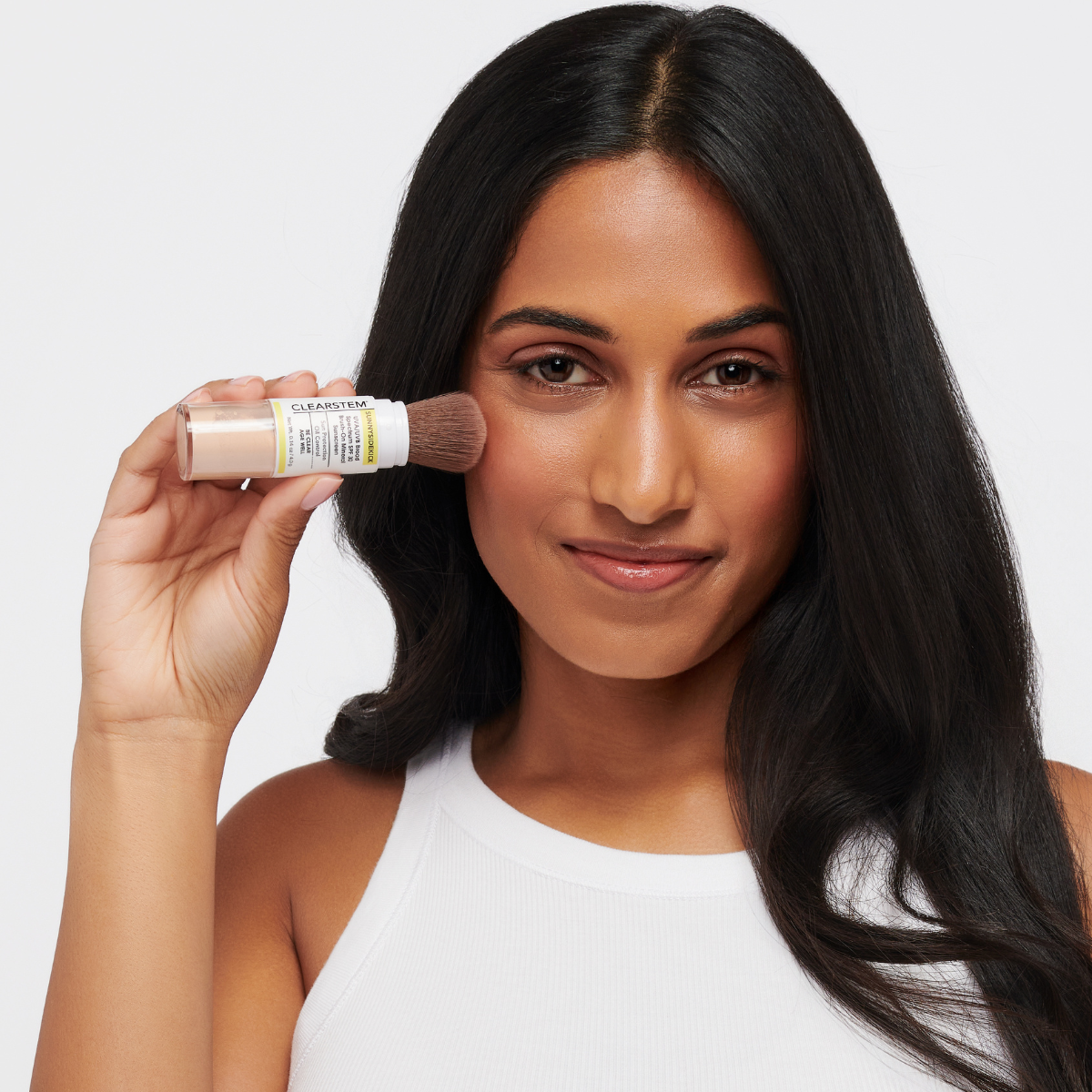 Girl using CLEARSTEM SUNNYSIDEKICK™, a brush-on mineral powder sunscreen